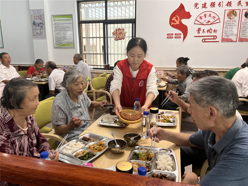 圖為志愿者為老人分發(fā)月餅。.png