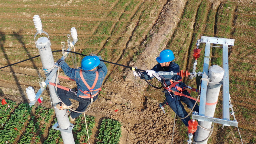 圖為電力工人正在15米高的電線桿上架設(shè)導(dǎo)線1 .jpg