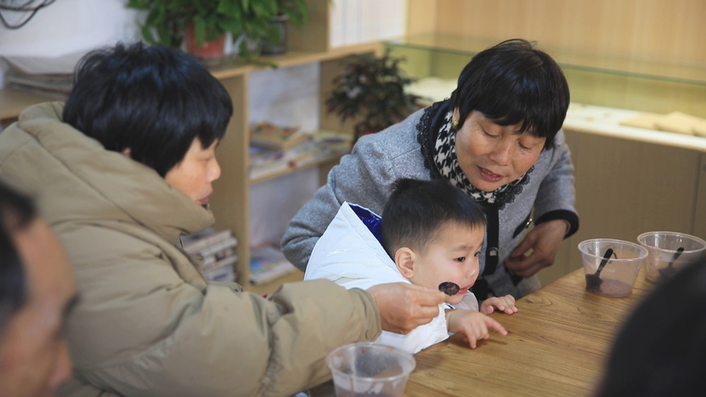 圖為社區居民正圍坐一起吃臘八粥，感受濃濃節日氛圍2.jpg