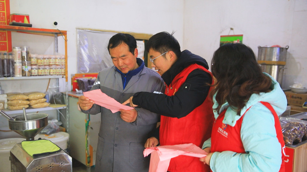 圖為志愿者正在給居民發放保護母親河倡議書1.jpg