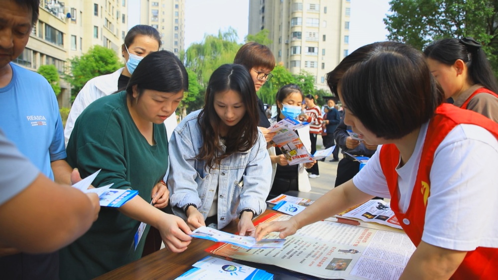 圖為龍眠街道王墩社區工作人員正在給小區居民發放防災減災知識宣傳單頁2.jpg