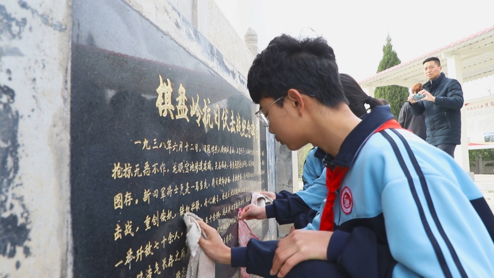 圖為參加活動的學(xué)生正在擦拭紀(jì)念碑1.jpg