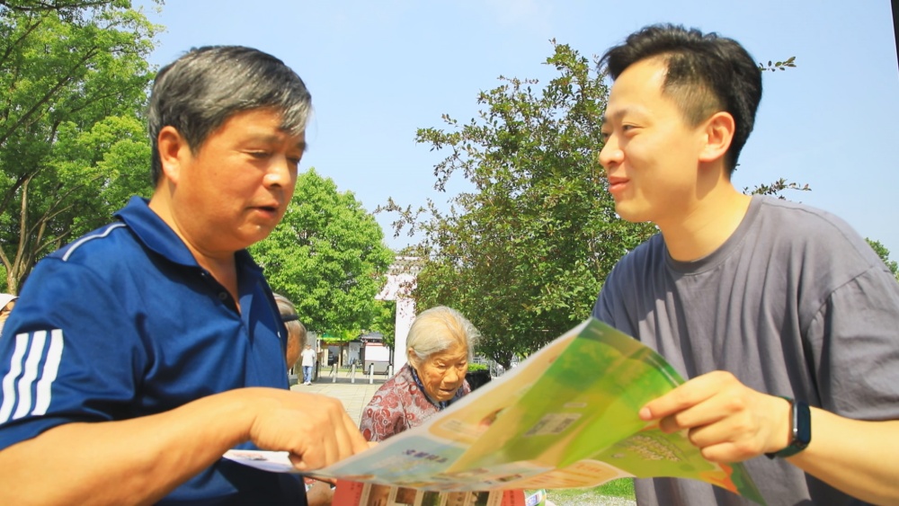 圖為工作人員正在為過往游客介紹桐城市旅游導覽圖.jpg