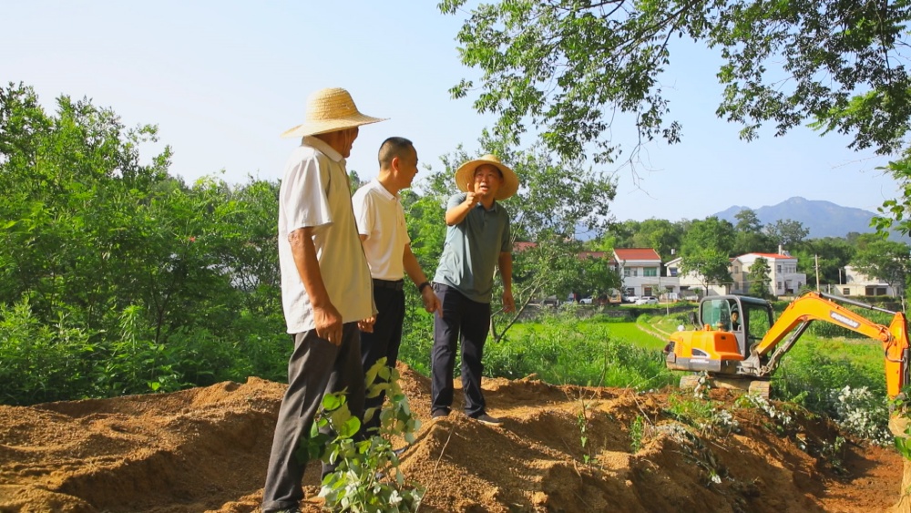 圖為當(dāng)?shù)劓?zhèn)村干部、村民一起現(xiàn)場檢查道路硬化工程施工質(zhì)量.jpg